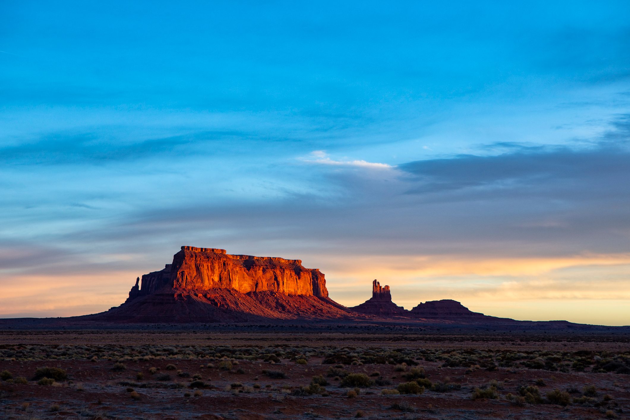 Red sandstone butte under a blue evening sky in the Arizona desert